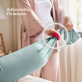 Person adjusting a bbhugme pregnancy pillow with text