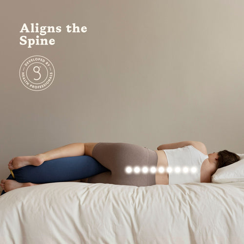 Person lying on a bed with a bbhugme pregnancy pillow under their head, aligning the spine.